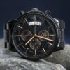 A luxurious black wristwatch showcasing precise timekeeping on natural stones.