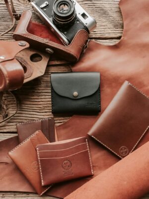 Artistic display of handcrafted leather wallets and vintage camera.
