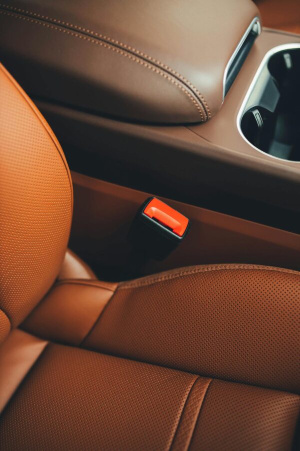 Close-up of a luxury car's brown leather interior showcasing sleek design and comfort.