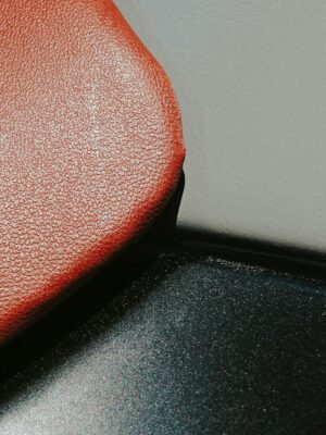 Detailed close-up showing the texture of a red leather seat, emphasizing the rich material.
