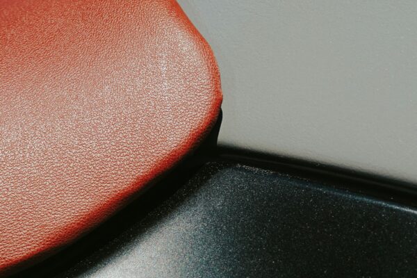 Detailed close-up showing the texture of a red leather seat, emphasizing the rich material.
